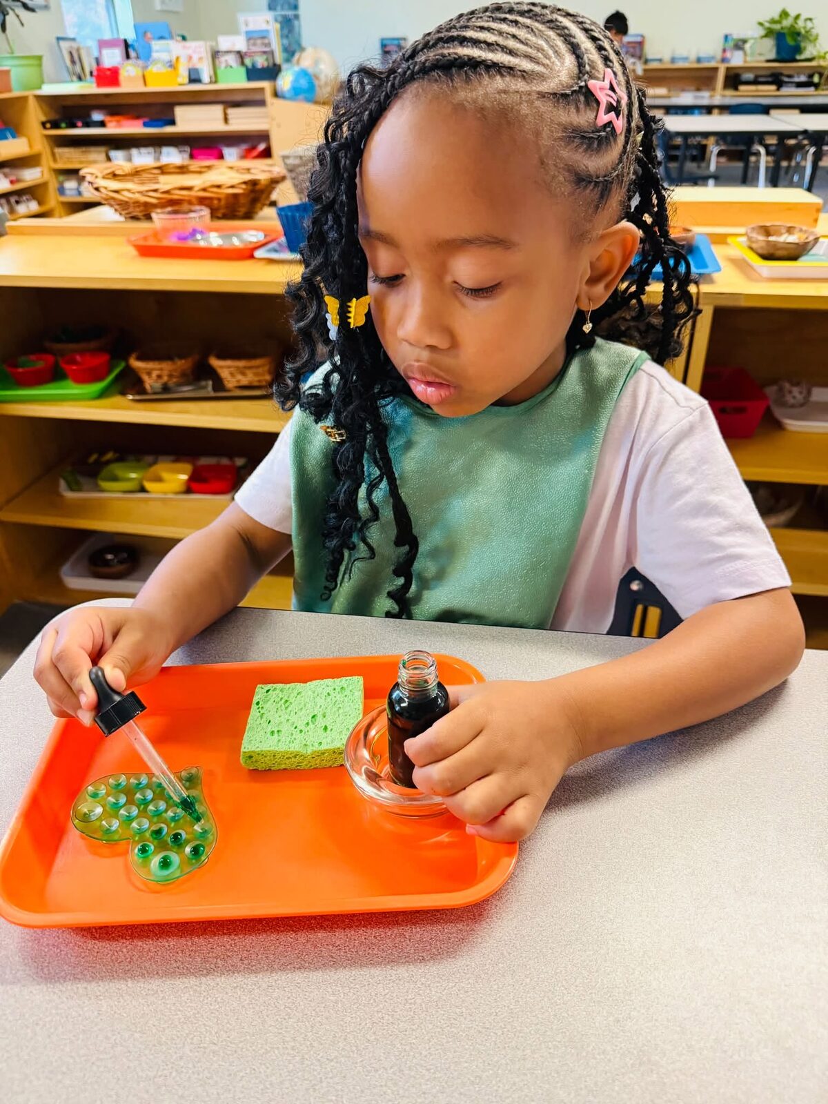 A student cleaning a bowl during a practical life lesson