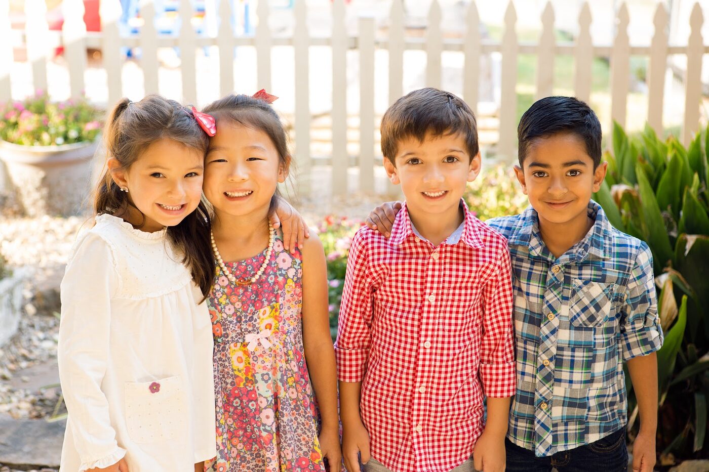 Four smiling children outside at Little Rock Montessori School