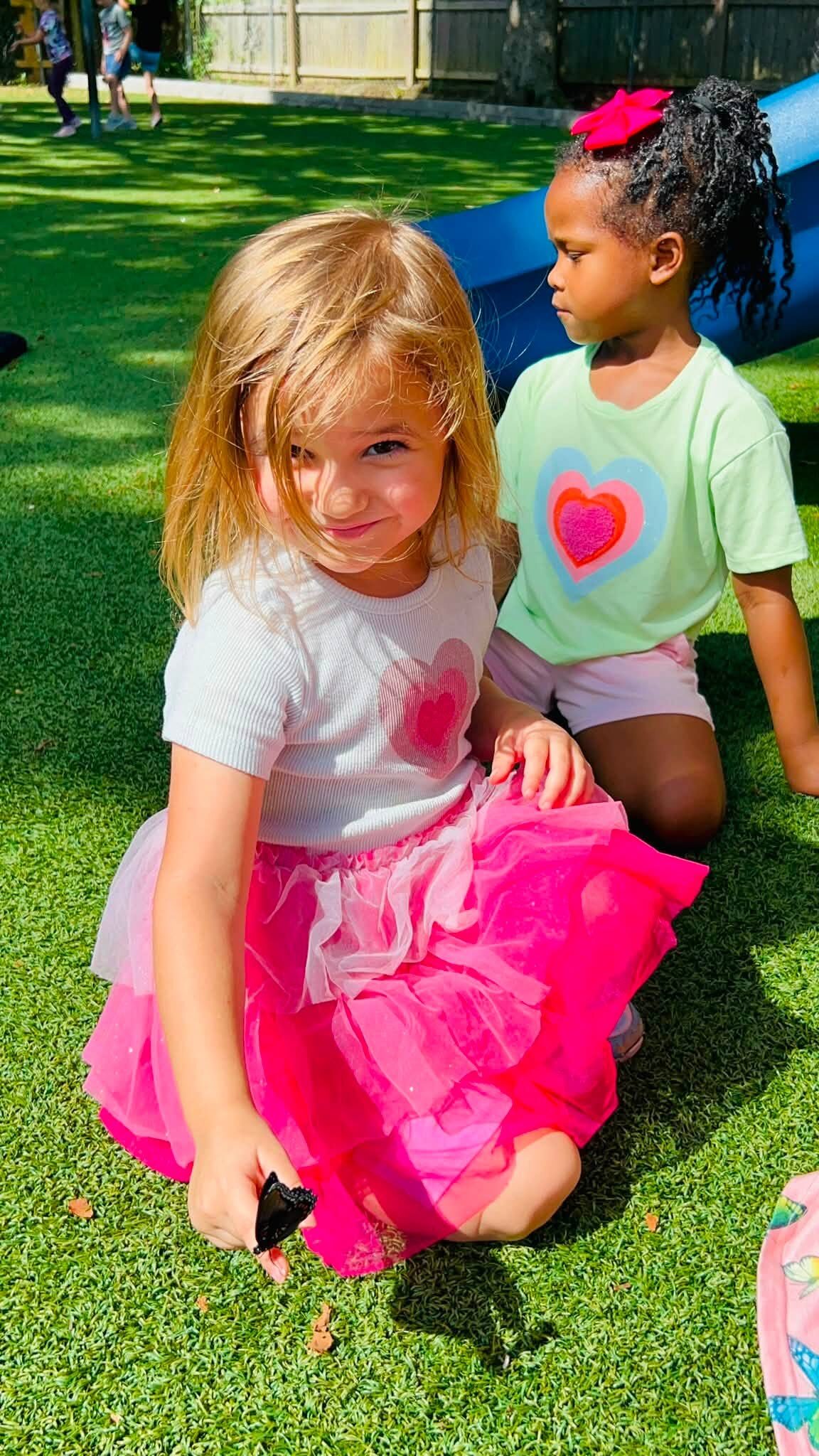 A child holding a book outside at Little Rock Montessori School