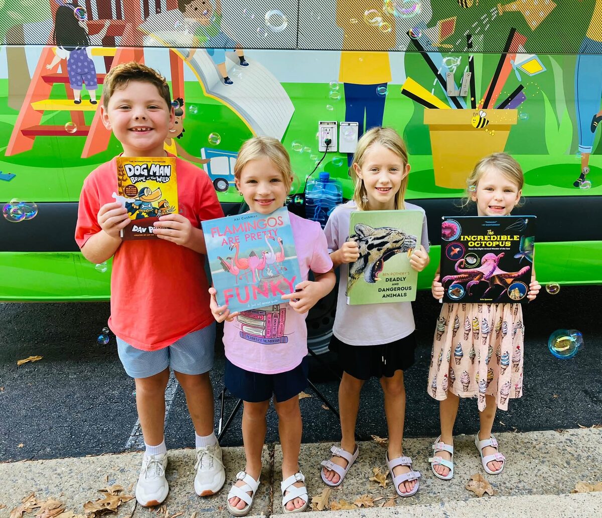 Elementary students exploring books together outside