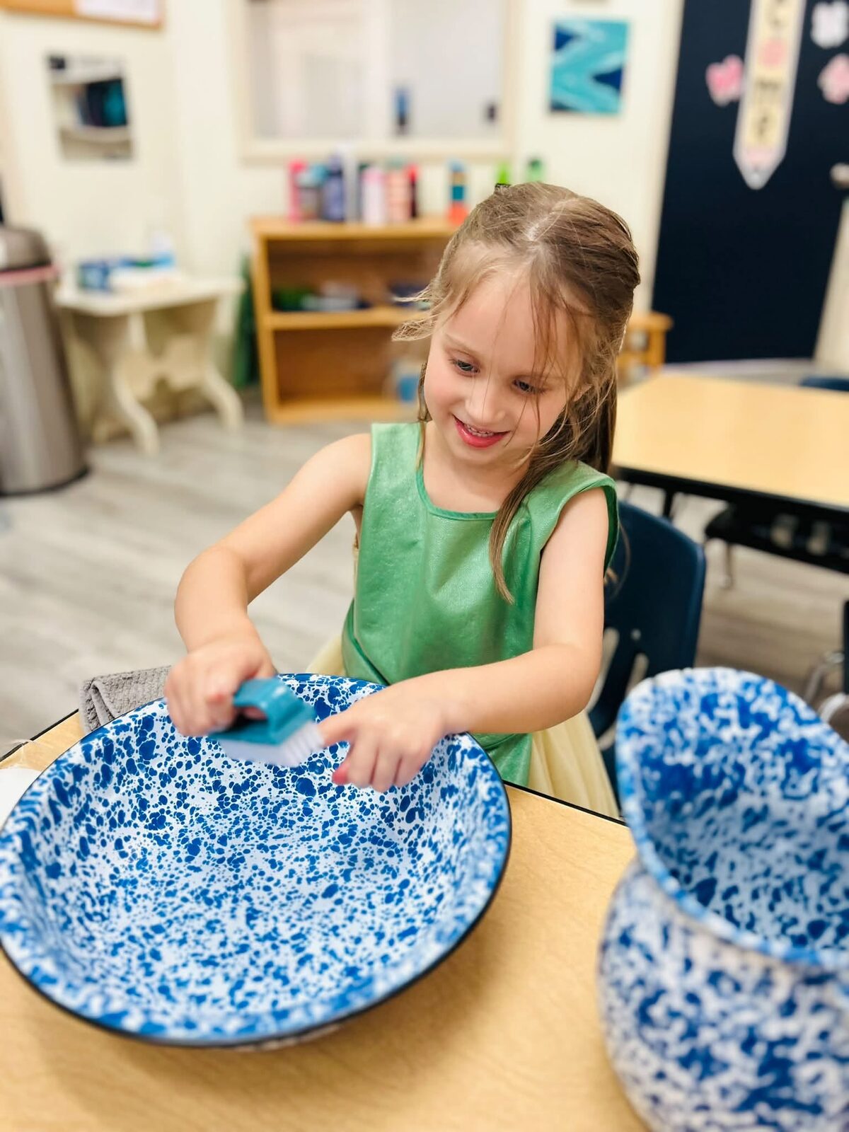 Toddler washing a bowl as part of a practical life activity